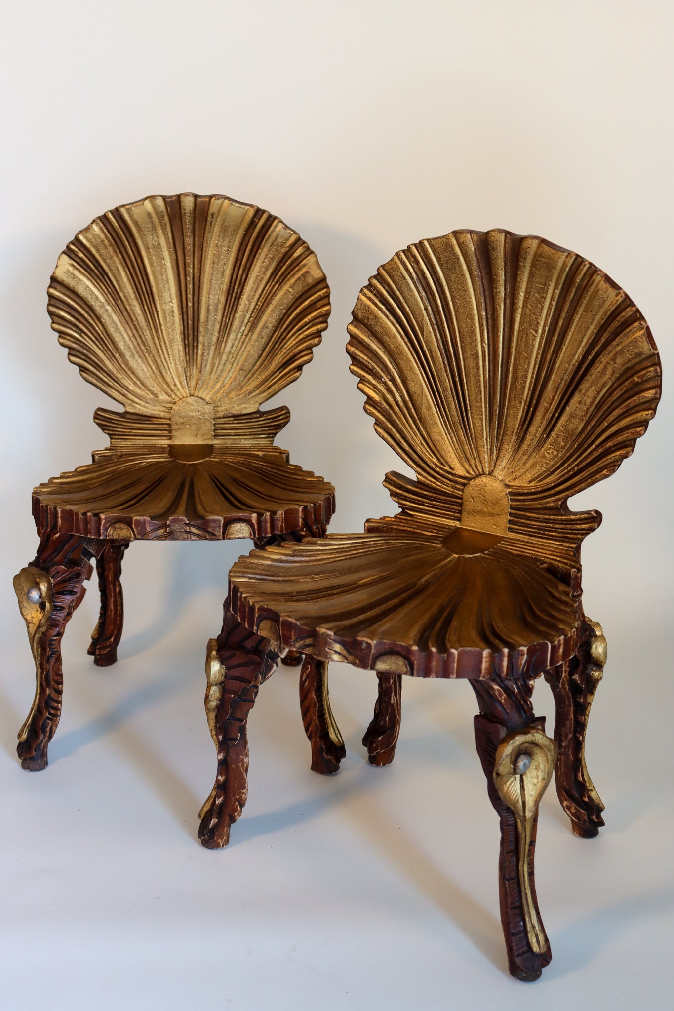 A pair of giltwood chairs, the shell form backs over shell form seats, with cabriole legs formed with pearls an shells.